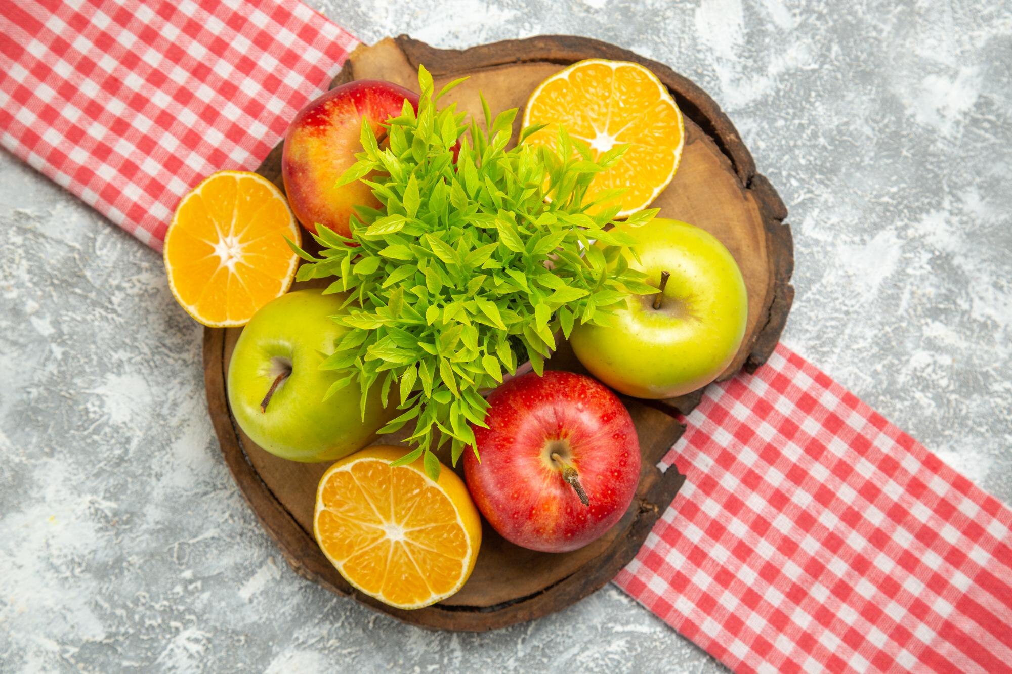 Tazón con alimentos naturales frescos, fruta y verdura colorida sobre una mesa de madera clara