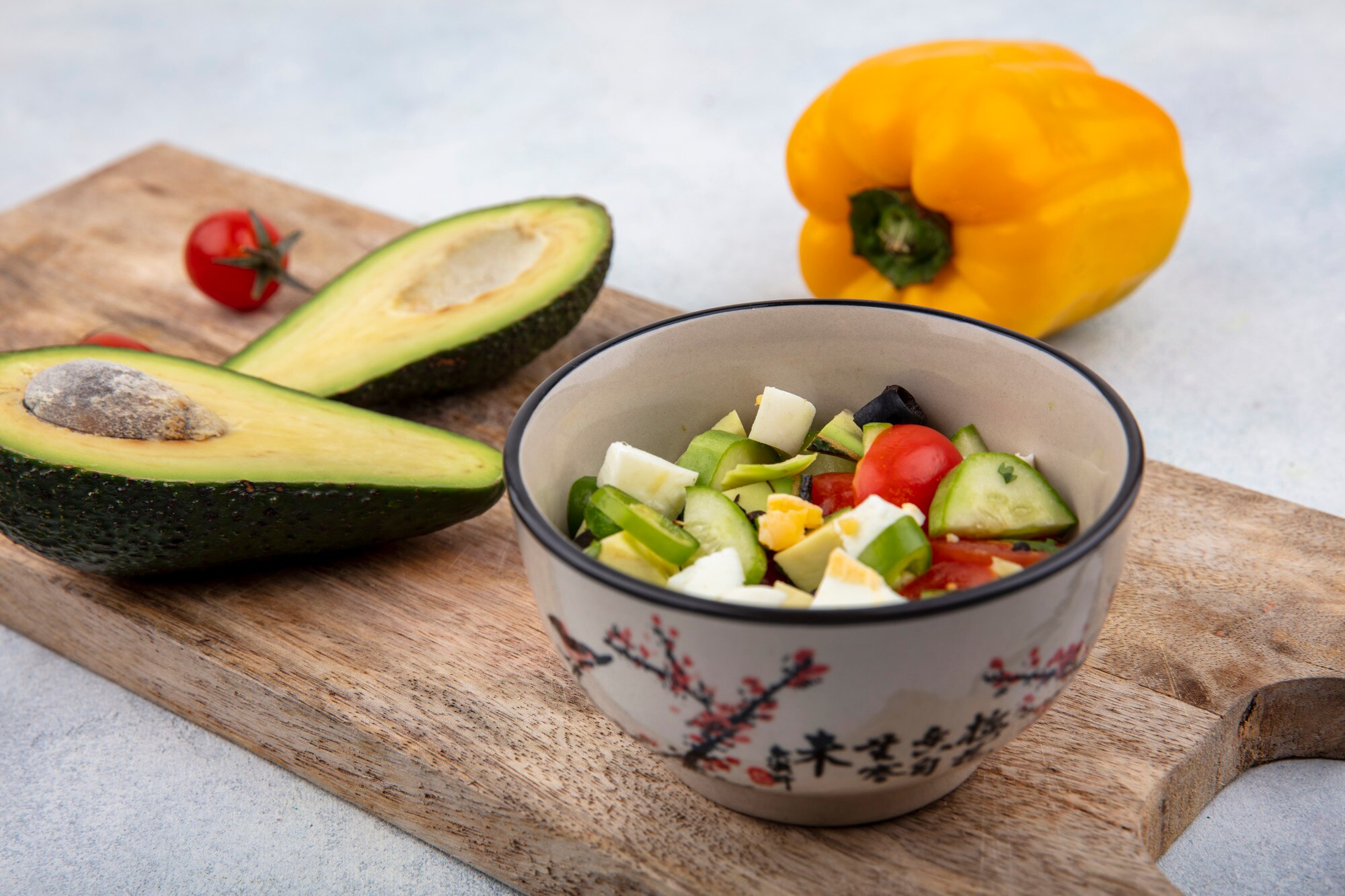 Plato de ensalada fresca con vegetales coloridos, nueces y aguacate sobre una mesa minimalista